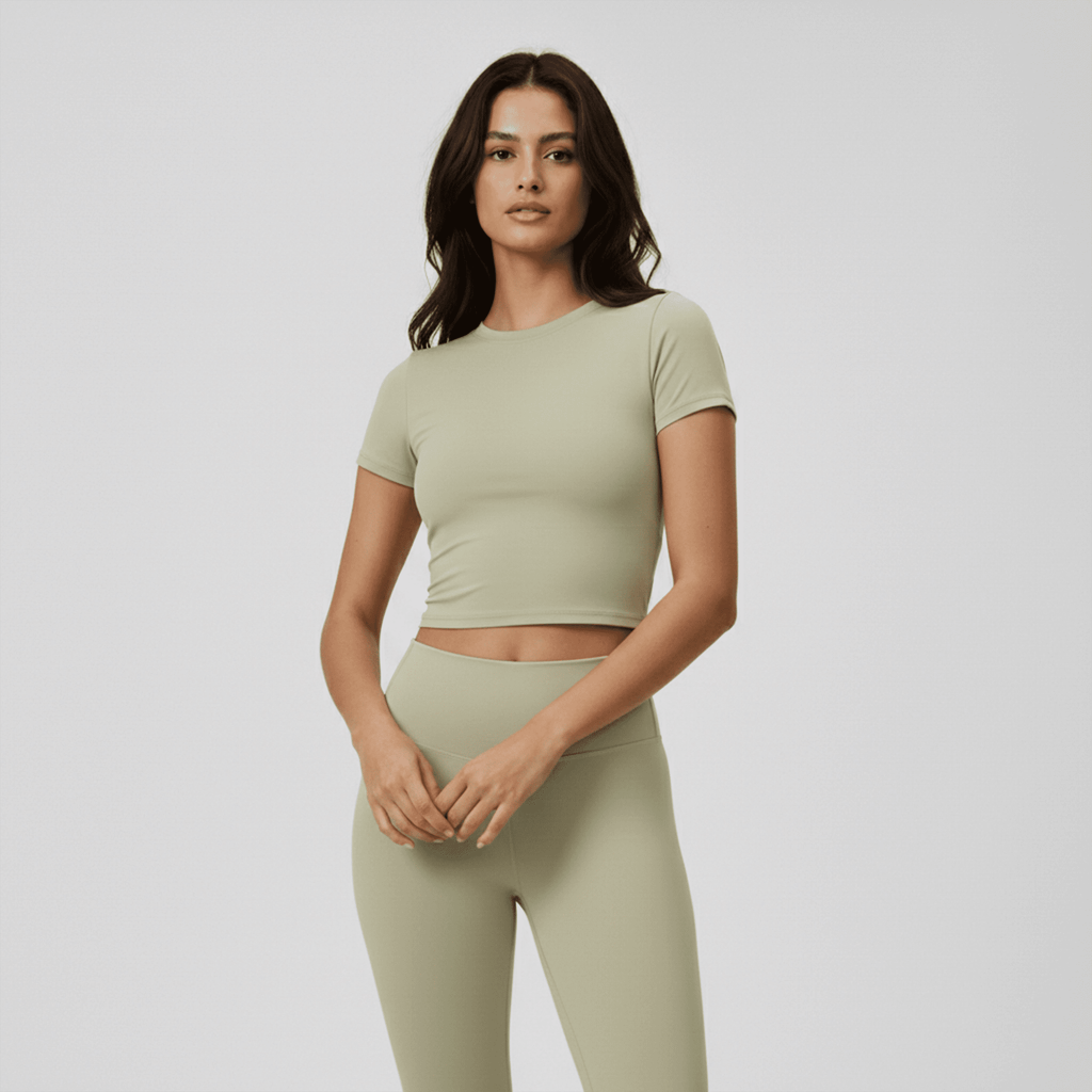 Woman wearing a green athletic outfit on a plain background