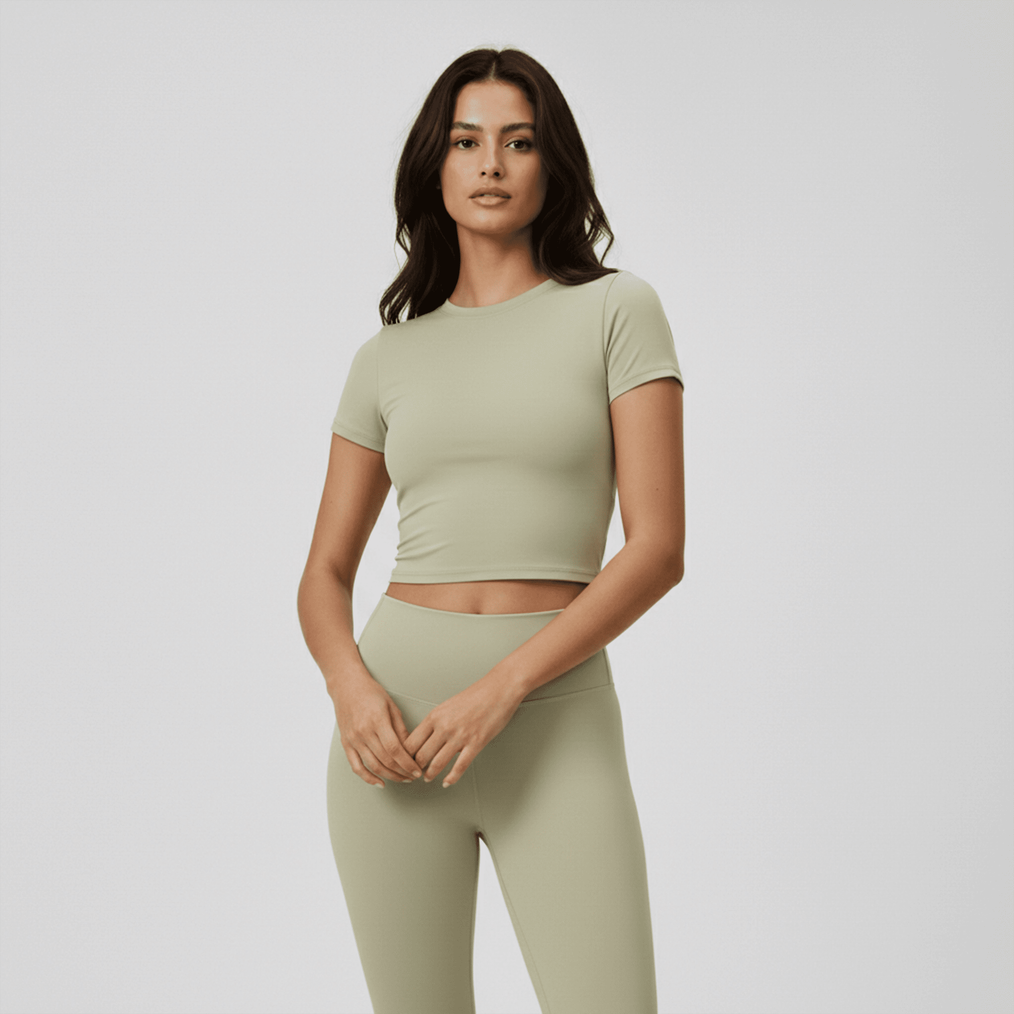 Woman wearing a green athletic outfit on a plain background