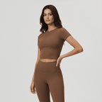 Woman wearing a brown athletic outfit on a light gray background
