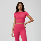 Woman wearing a bright pink athletic outfit on a light gray background
