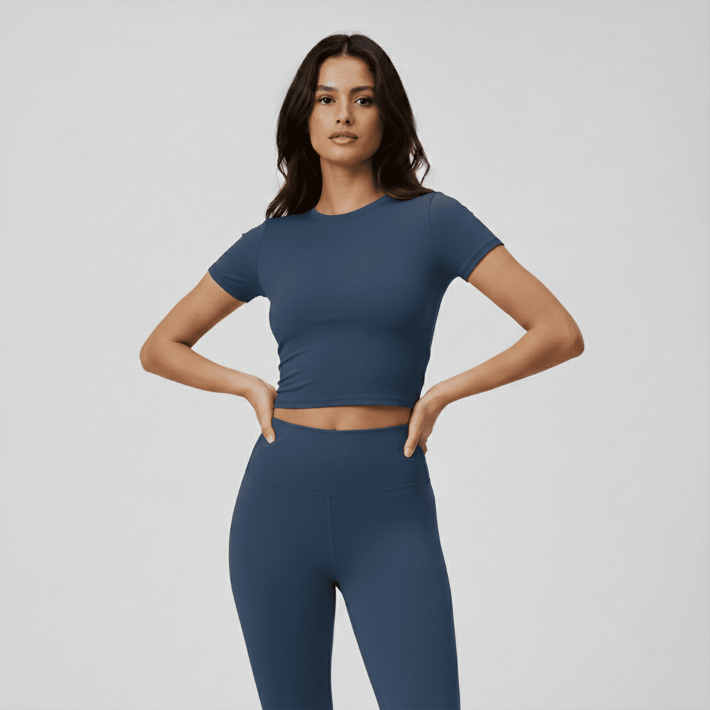 Woman wearing a blue athletic outfit on a plain background