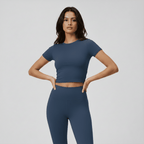 Woman wearing a blue athletic outfit on a plain background