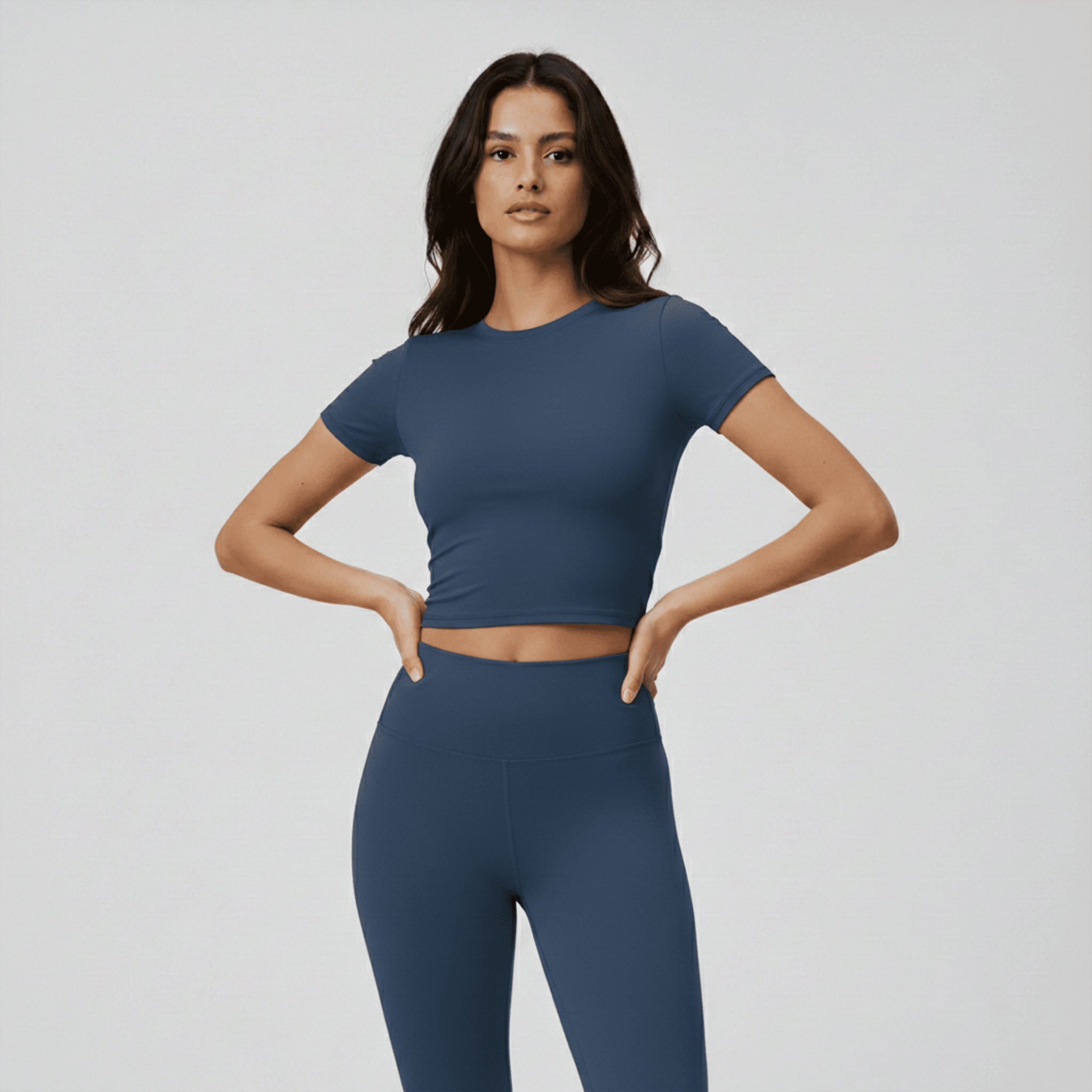 Woman wearing a blue athletic outfit on a plain background
