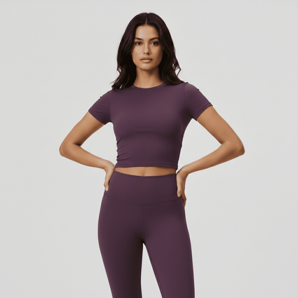 Woman wearing a purple athletic outfit on a plain background