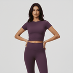 Woman wearing a purple athletic outfit on a plain background