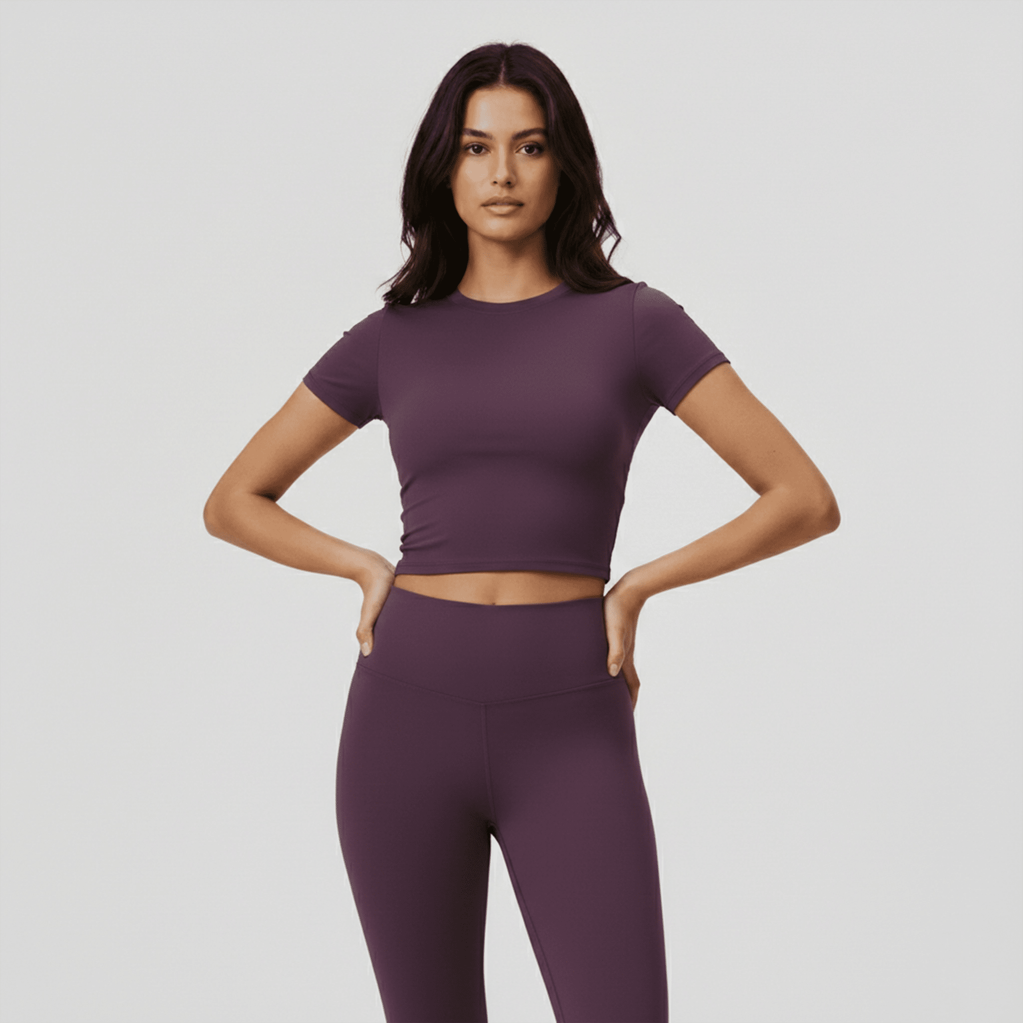 Woman wearing a purple athletic outfit on a plain background