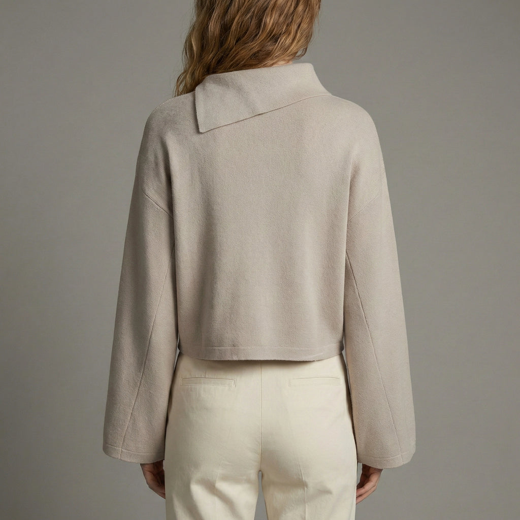 Person wearing a beige jacket and pants against a gray background