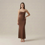 Woman wearing a brown slip dress against a plain background