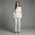 Woman wearing a white suit against a gray background