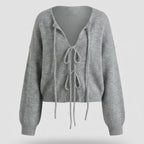 Gray knitted cardigan with tie details on a light gray background