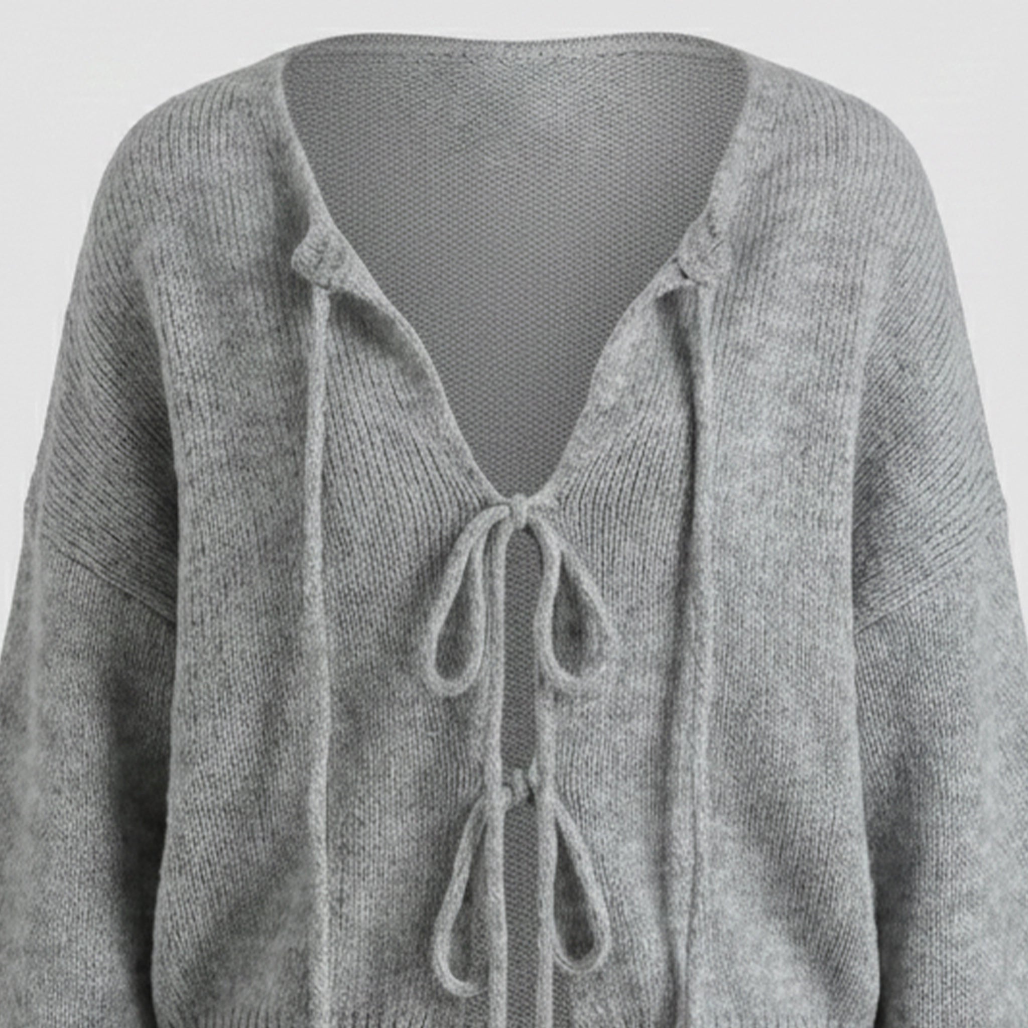 Gray knitted cardigan with tie details on a light gray background