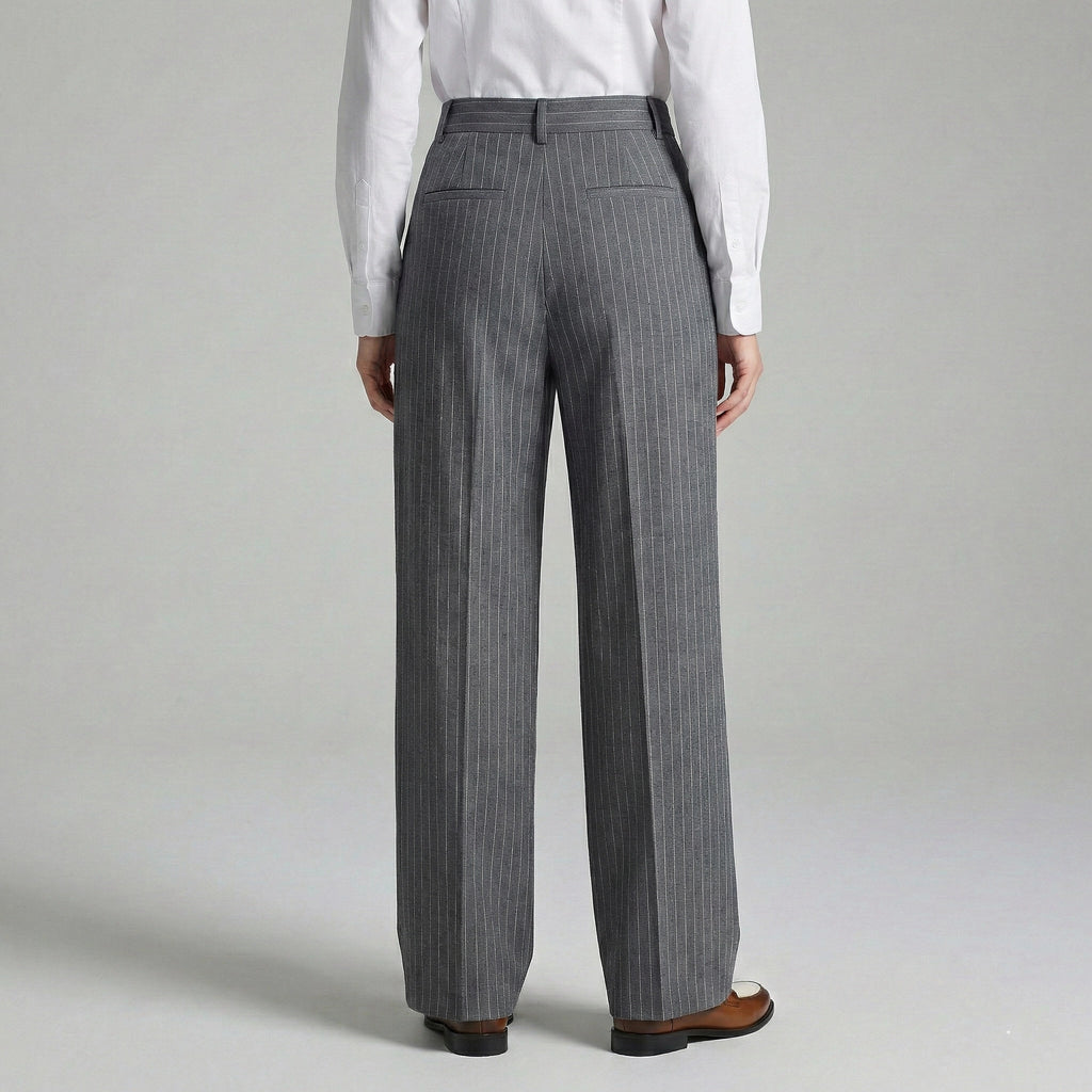 Person wearing gray pinstripe pants and a white shirt on a plain background