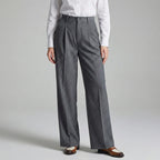 Person wearing gray pinstripe pants and a white shirt on a light gray background