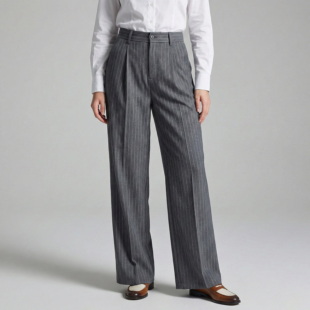 Person wearing gray pinstripe pants and a white shirt on a light gray background