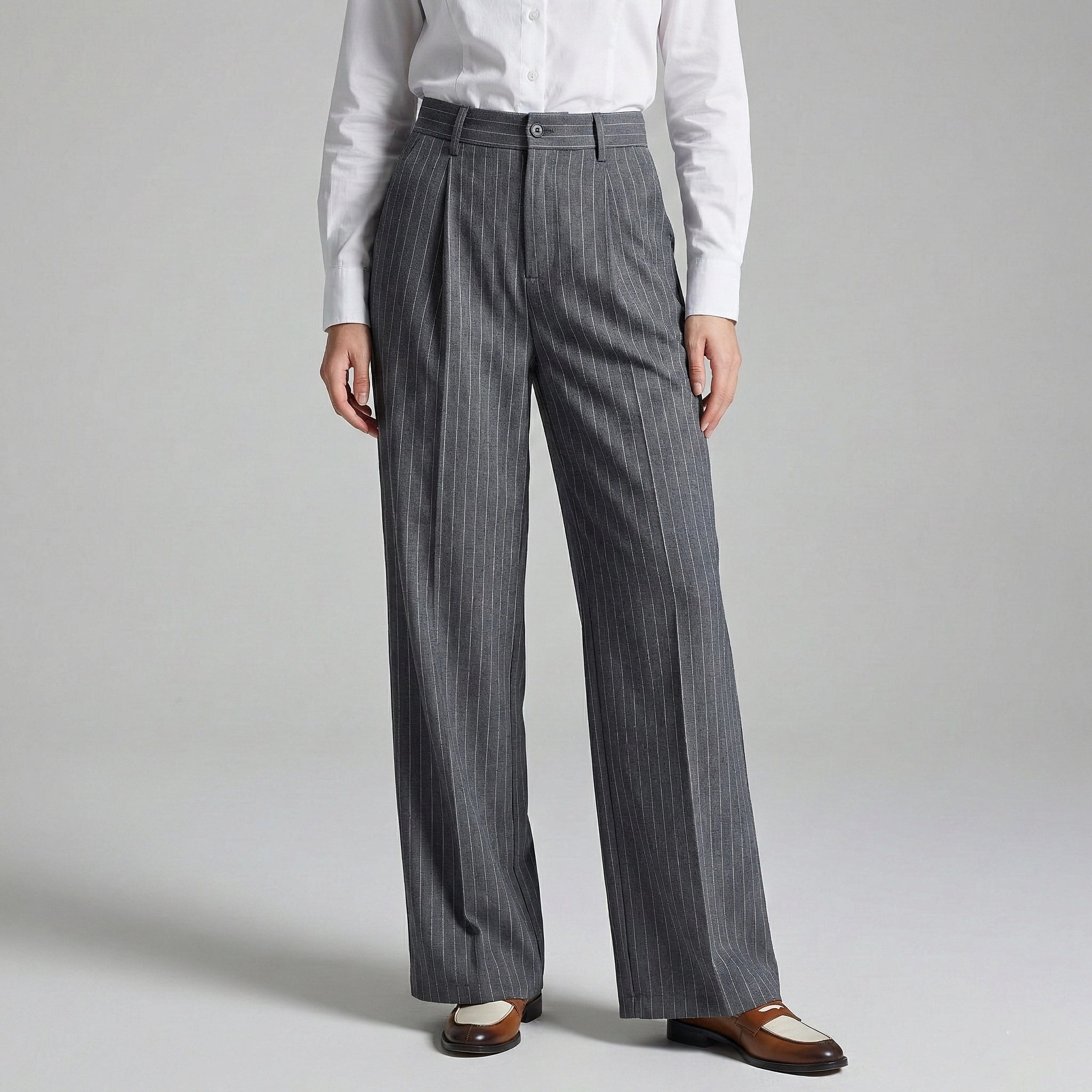 Person wearing gray pinstripe pants and a white shirt on a light gray background
