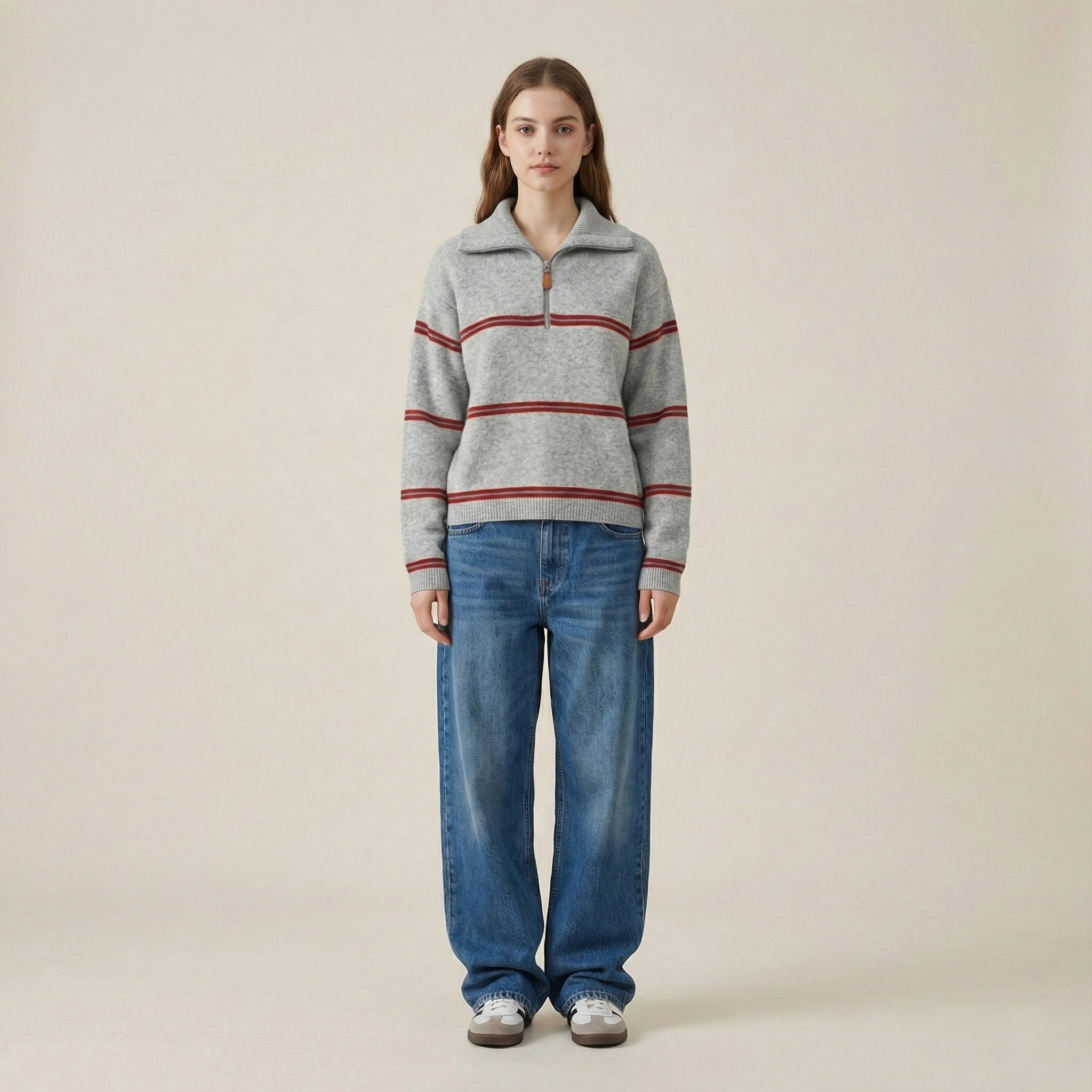 Person wearing a striped sweater and jeans on a beige background