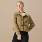 Woman wearing a beige jacket on a gray background