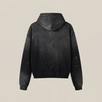 Black hoodie with splatter design on a beige background