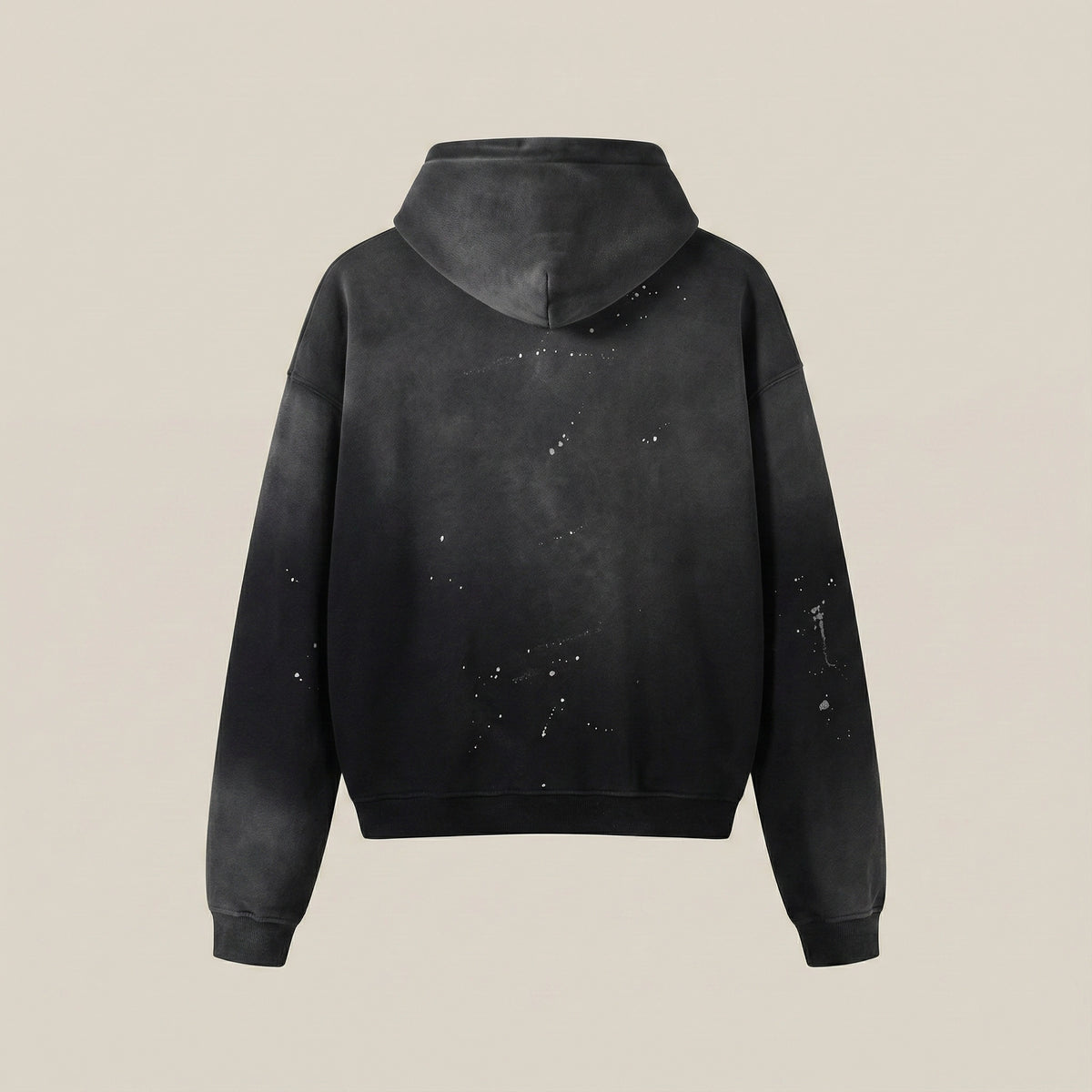 Black hoodie with splatter design on a beige background