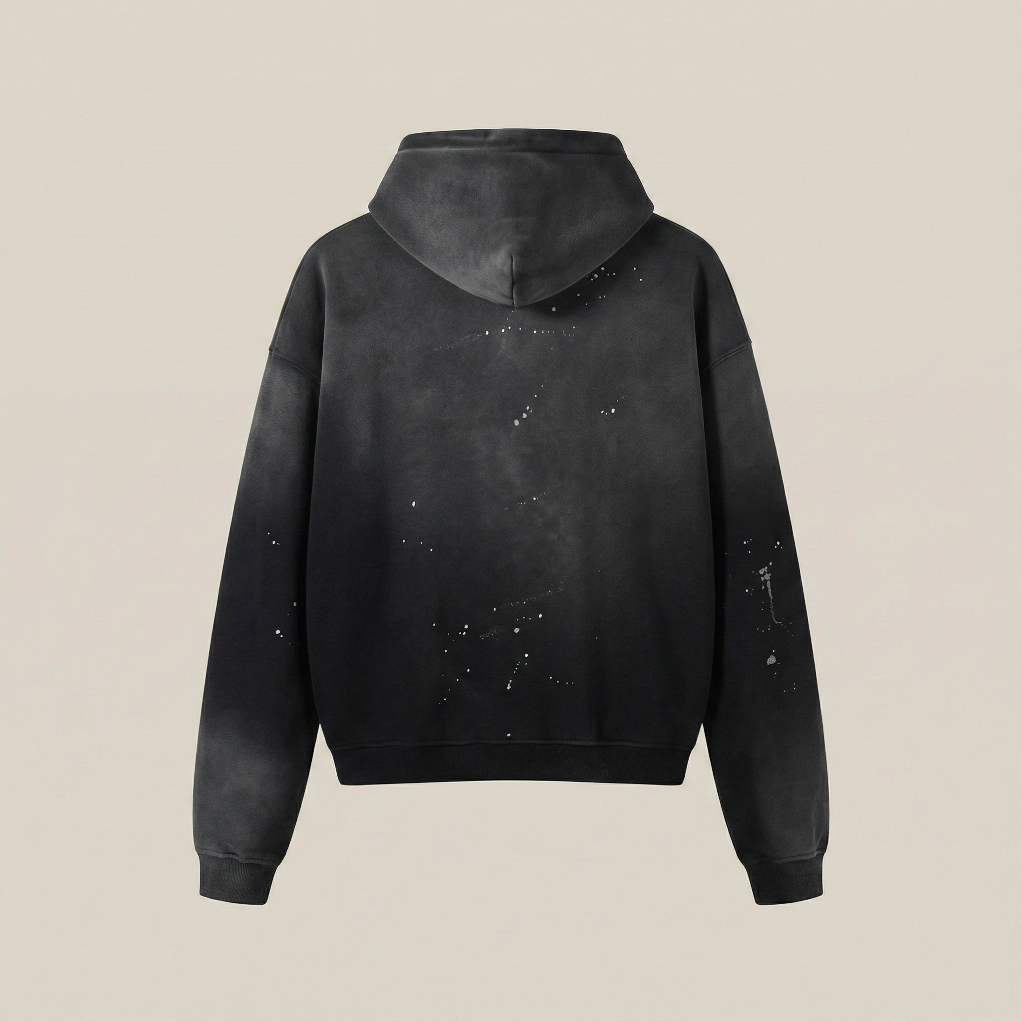 Black hoodie with splatter design on a beige background