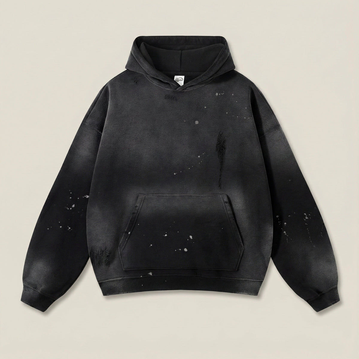 Black hoodie with splatter design on a beige background