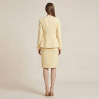 Woman wearing a light yellow suit on a beige background