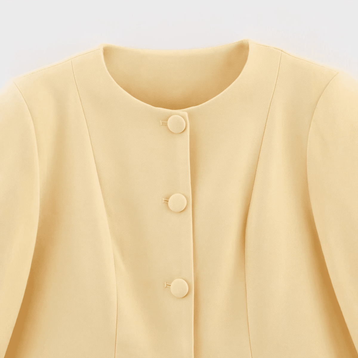 Yellow cardigan with buttons on a light gray background