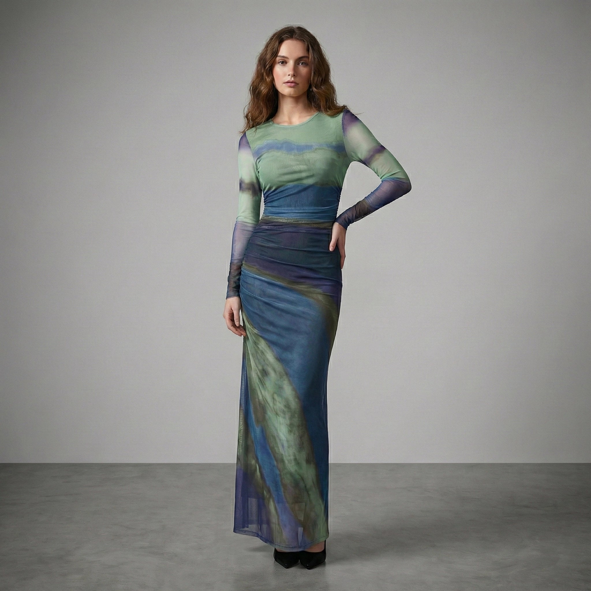 Woman wearing a long, patterned dress against a plain background