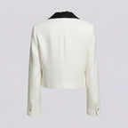 White blazer with black lapels on a light gray background