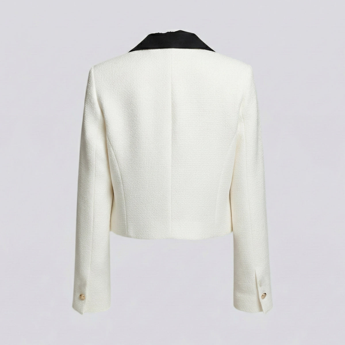 White blazer with black lapels on a light gray background