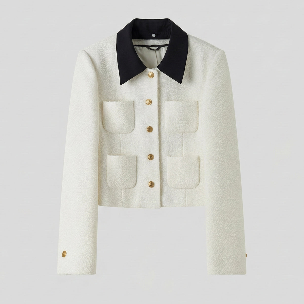 White jacket with black collar and gold buttons on a light gray background