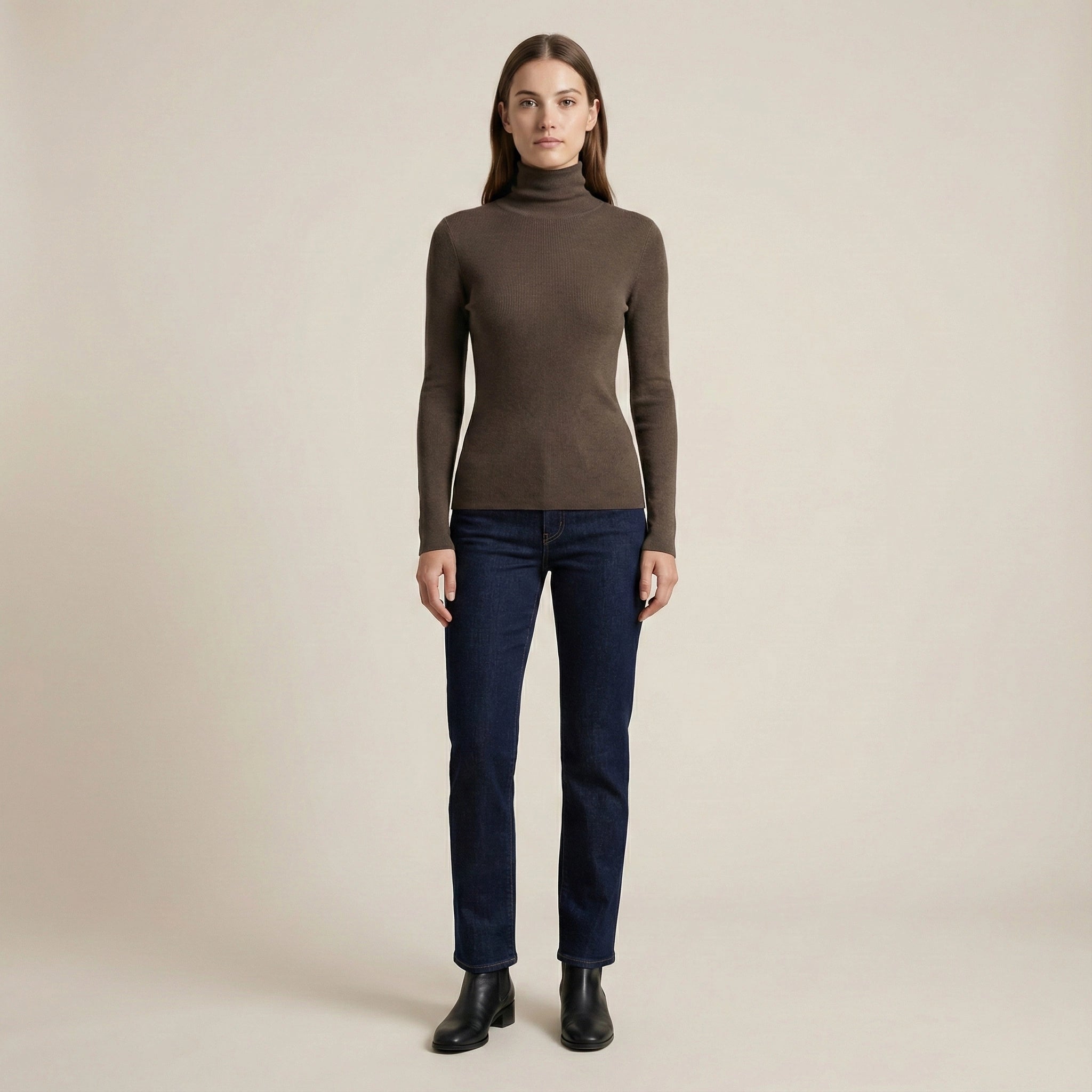 Woman wearing a brown turtleneck sweater and dark blue jeans on a beige background