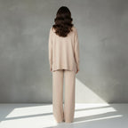 Woman wearing a beige suit on a light gray background