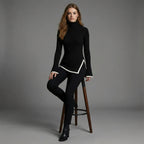 Woman wearing a black turtleneck and pants on a gray background