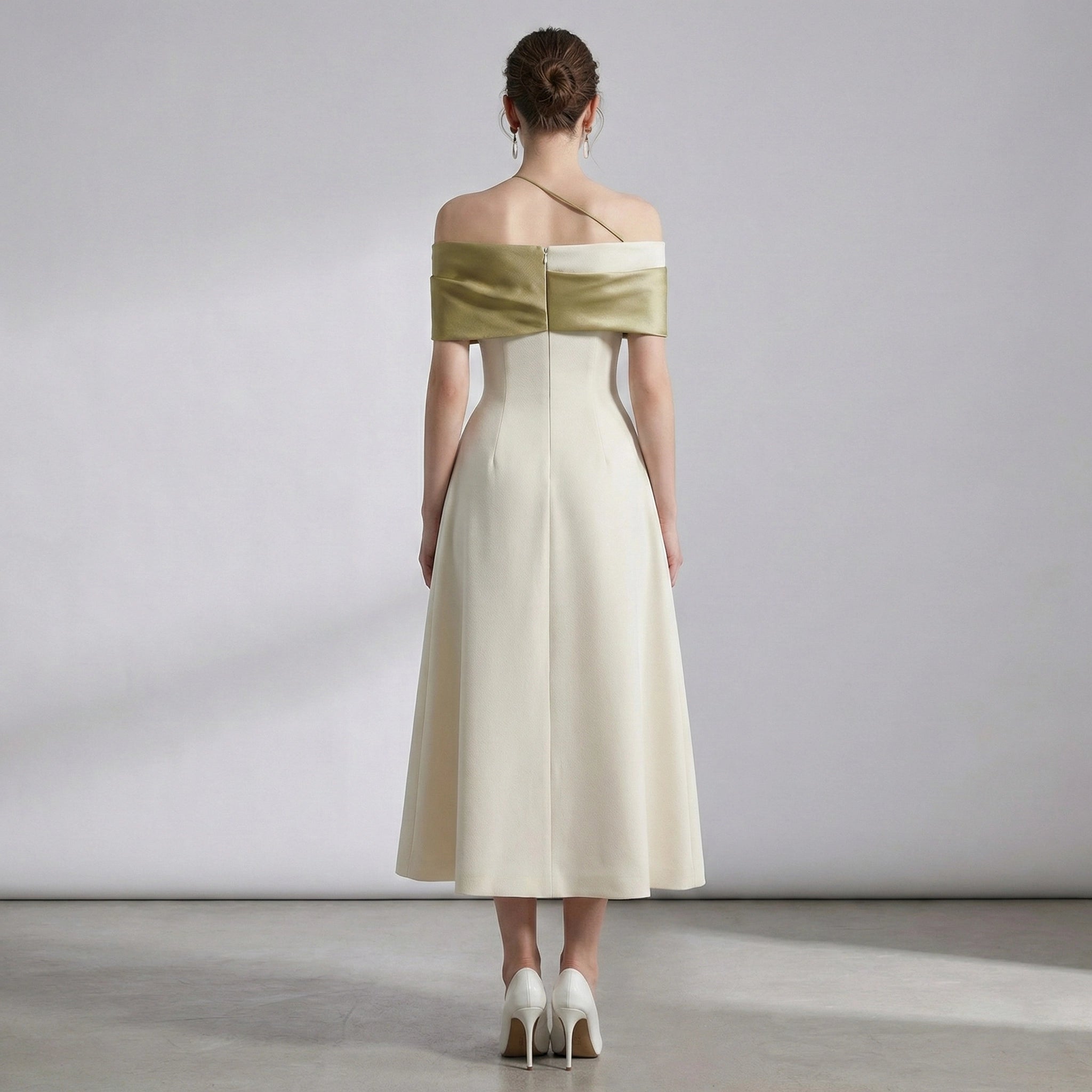 Woman wearing a gold and white dress with a plain background