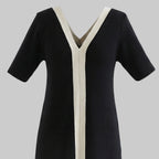 Black dress with white trim on a white background