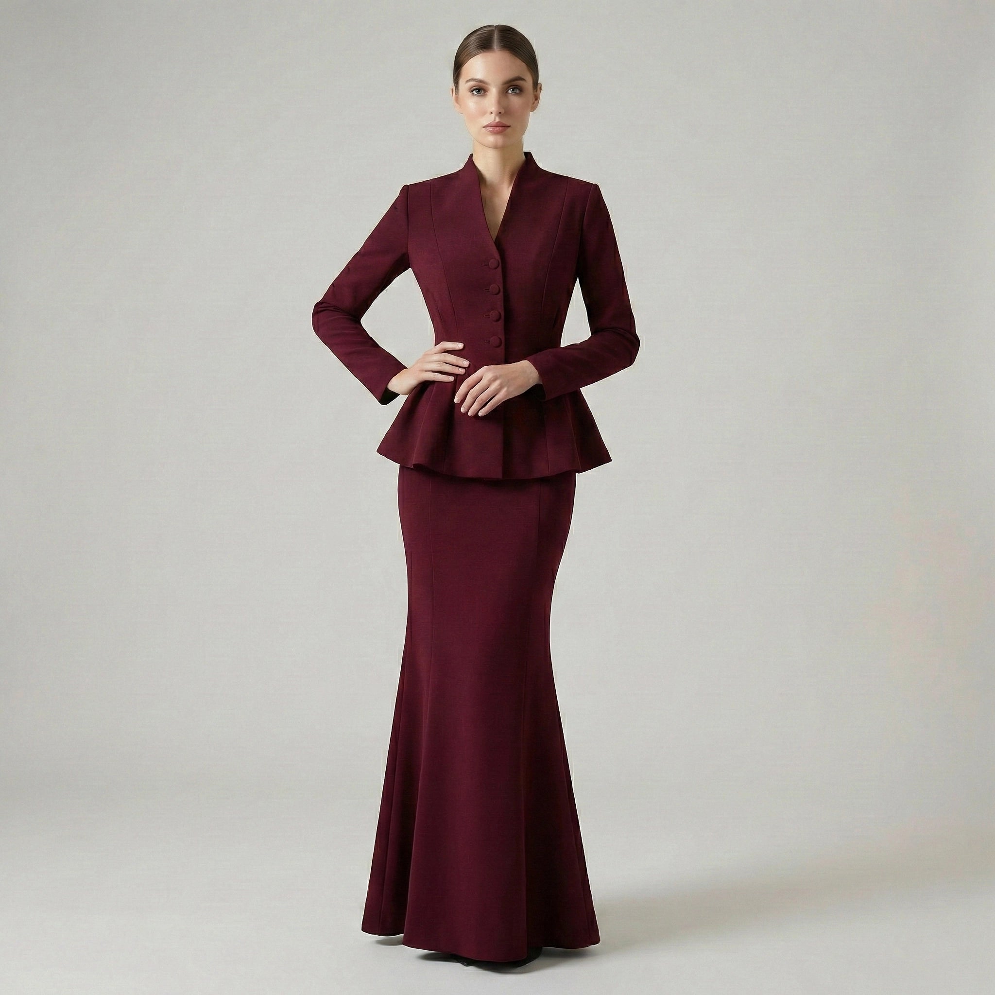 Maroon evening gown with peplum top on a plain background