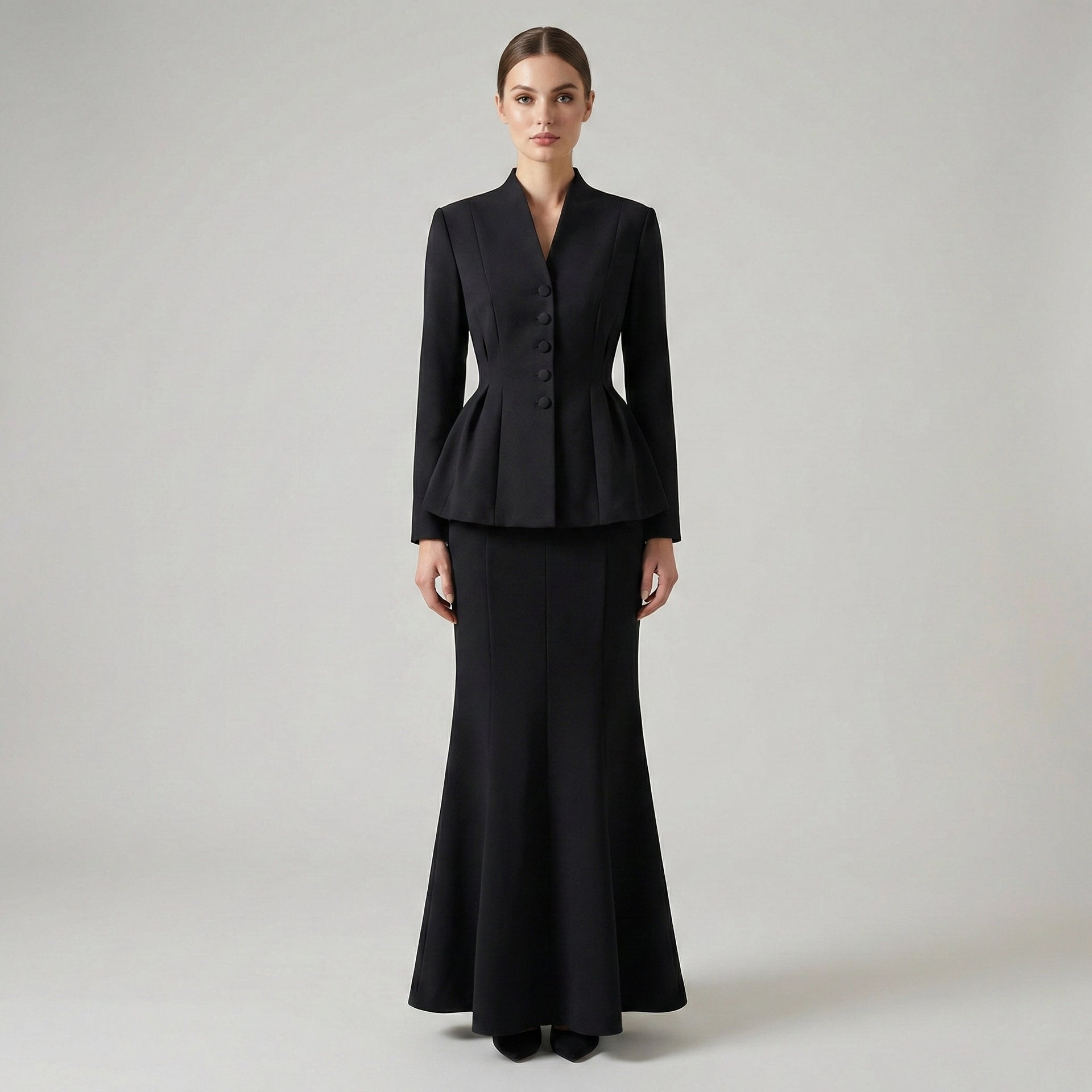 Woman wearing a black suit on a plain background