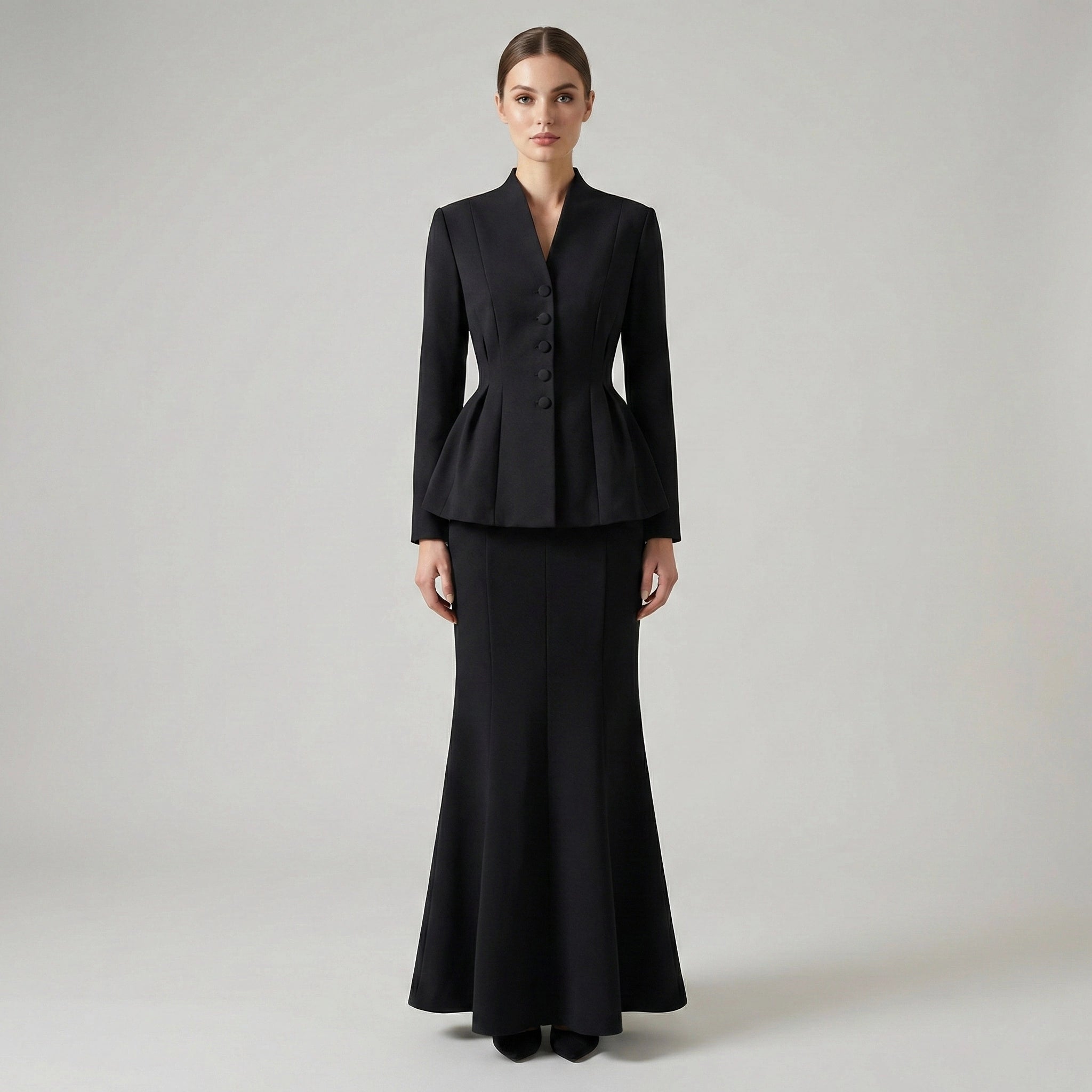 Woman wearing a black suit on a plain background