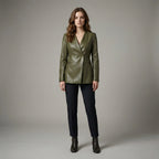 Woman wearing a green leather jacket and black pants on a gray background