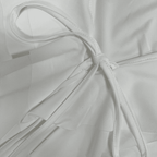 Close-up of a white fabric with a bow detail