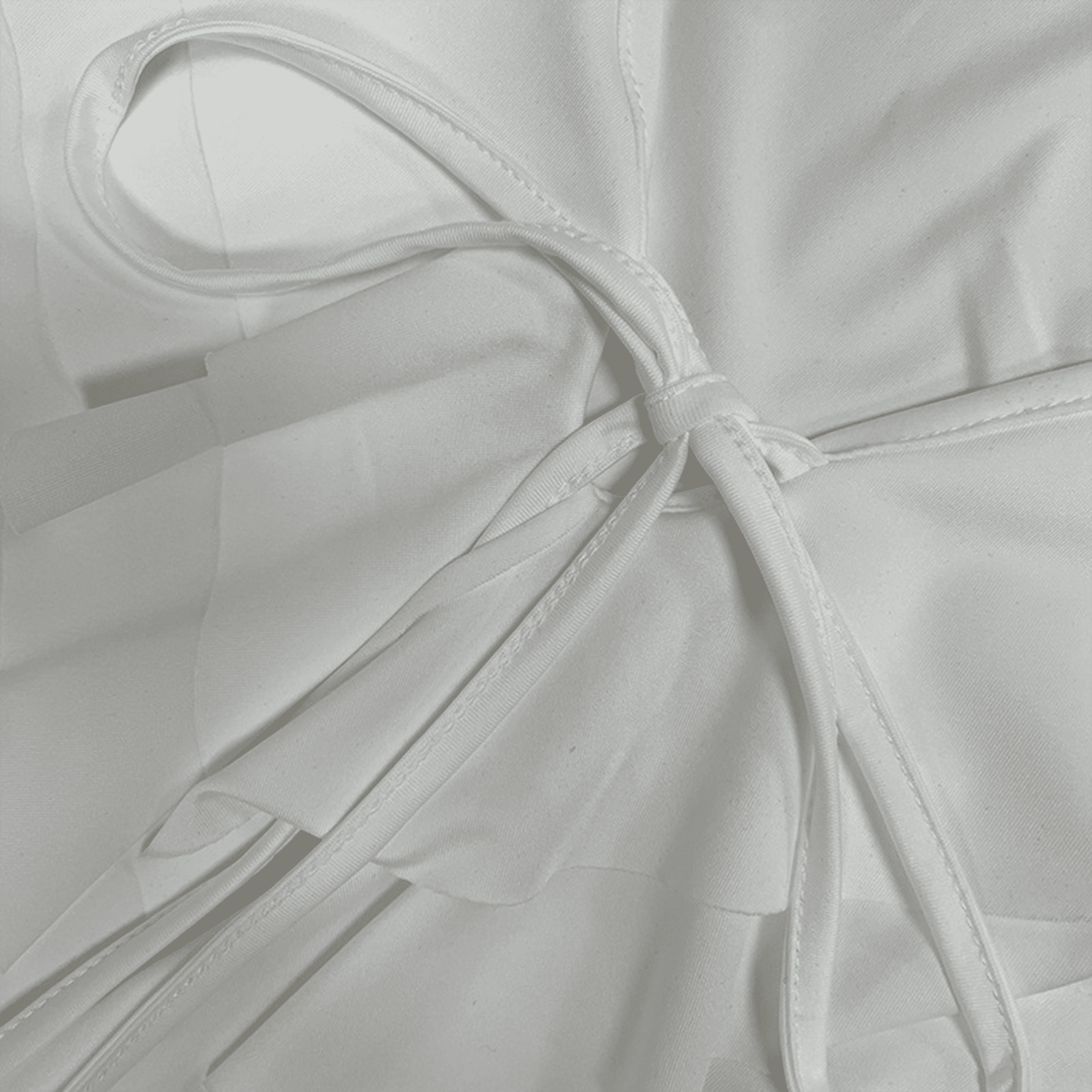 Close-up of a white fabric with a bow detail