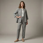 Woman wearing a gray suit with a white shirt on a beige background