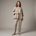 Woman wearing a beige suit with a plain background