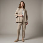 Woman wearing a beige suit with a plain background