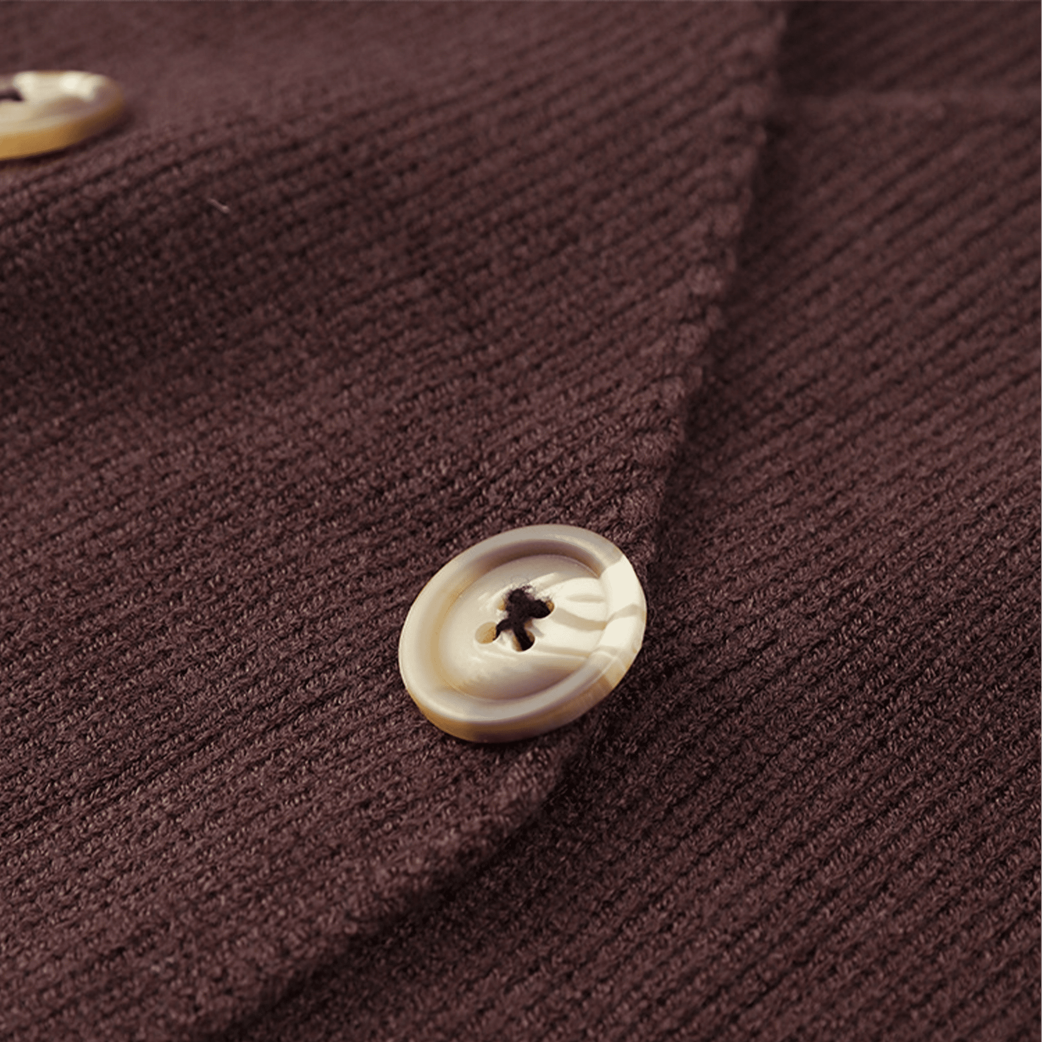 Close-up of a button on a textured brown fabric