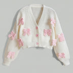White sweater with pink bows on a gray background
