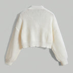 White knit cardigan on a light gray background