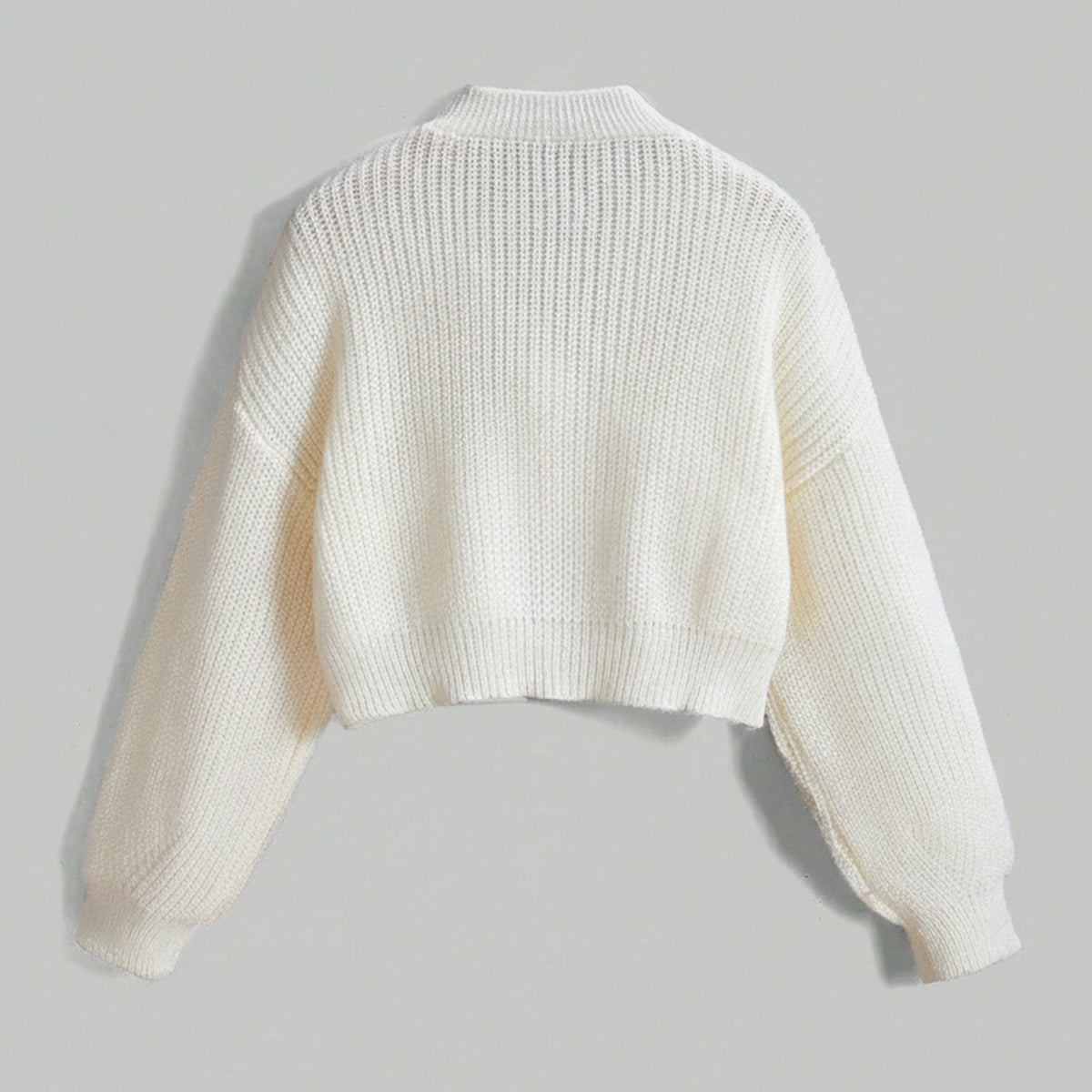 White knit cardigan on a light gray background