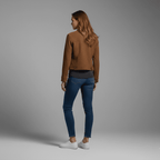 Woman wearing a brown jacket and blue jeans on a gray background